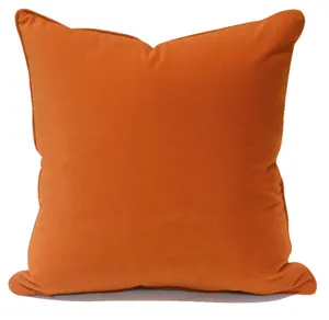 Détail de housse de coussin orange avec passepoil élégant, coussin style nordique moderne.