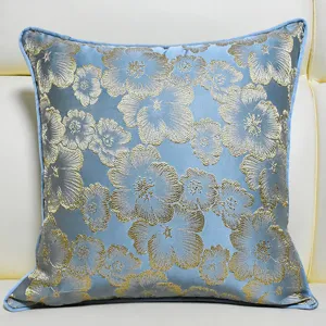 Close-up detail of blue jacquard cushion cover featuring elegant gold floral pattern.