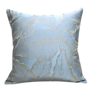 Detail view of luxury blue gold jacquard pillow cover with botanical leaf design sofa.