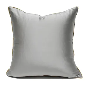 Modern minimalist square throw pillow in grey-brown satin with stylish gold piping.