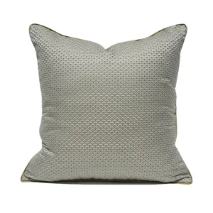 Modern minimalist square throw pillow with grey wave pattern and gold piping for living room sofa.