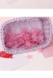 Close-up detail shot of pink luminous star wall stickers in a purple woven basket decor.