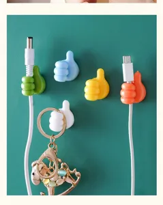 Primer plano ganchos de pared con forma de pulgar de colores, organizador de cables.