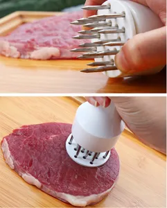 Gros plan sur les aiguilles d'assouplisseur de viande en acier dans du bœuf.