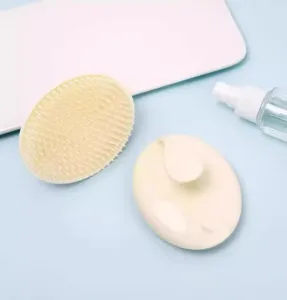 Brosse de massage du cuir chevelu en silicone et flacon pulvérisateur pour soins capillaires.