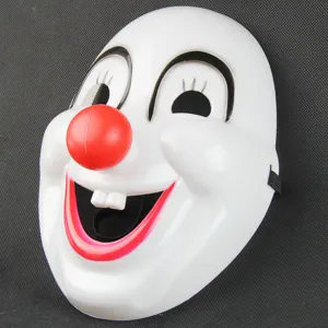 Plastic clown mask detail view featuring red nose, white teeth and black elastic strap for party.