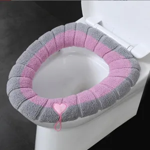 Thickened plush toilet seat cover in grey and pink with heart handle, comfortable household mat.