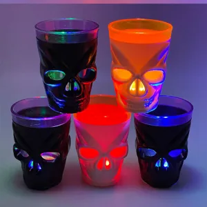 Primo piano del set di bicchieri da shot teschio luminoso a LED per dettagli festa bar Halloween.