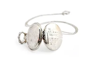 Vintage silver pocket watch with detailed engraved castle pattern and long matching chain.