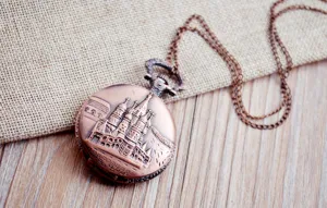 Vintage bronze pocket watch with delicate cathedral embossed design and long chain accessory.