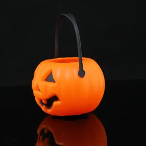 Close-up detail of the classic orange plastic Halloween pumpkin candy bucket with black handle.