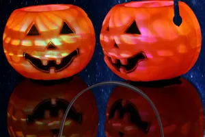 Halloween glowing pumpkin lantern detail, colorful holographic plastic candy jar for party decor.
