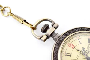 Detailed shot of vintage bronze quartz pocket watch with chain and Roman numerals dial face.