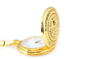 Close-up detail shot of vintage gold pocket watch with engraved text lid for son gift.