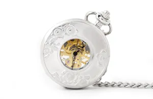 Detailed view of silver mechanical pocket watch, vintage skeleton dial with carved design.