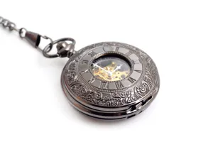 Orologio da tasca meccanico vintage con quadrante scheletrato e custodia decorata.