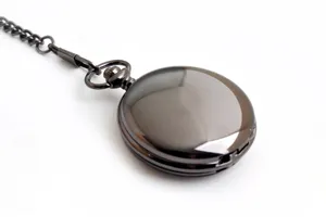 Primo piano di un classico orologio da tasca meccanico liscio con catena in metallo.