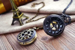 Vintage mechanical pocket watch with hollow digital wheel design and chain, detail view.