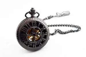 Antique black mechanical pocket watch with chain, vintage hollow skeleton dial design detail view.