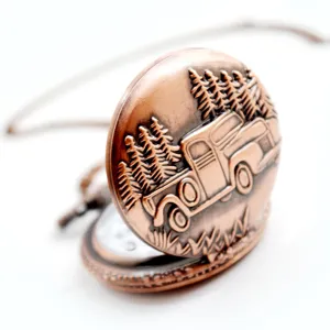 Vintage bronze pocket watch featuring an engraved truck and pine tree design with chain.