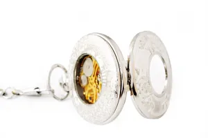 Vintage silver hollow mechanical pocket watch with detailed carved case and chain detail.