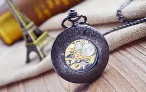 Detail view of vintage mechanical pocket watch, ornate carved case, skeleton gear movement.
