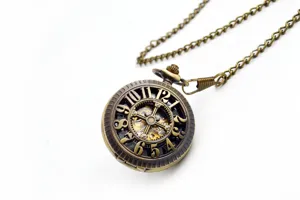 Close-up of vintage bronze mechanical pocket watch with hollow gear design and metal chain.