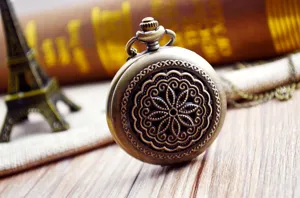 Gros plan de la montre de poche rétro en bronze avec motif floral ajouré sculpté en détail.