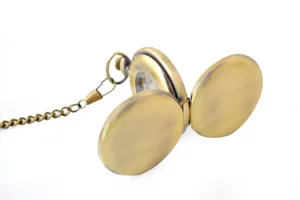 Detailed view of vintage bronze mechanical pocket watch with open double covers and metal chain.