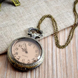 Vintage bronze pocket watch detail, retro quartz timepiece with long chain and brown dial.