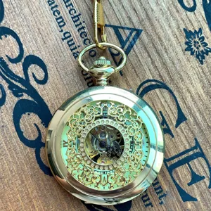 Vintage golden skeleton mechanical pocket watch with hollow floral filigree and roman numerals.
