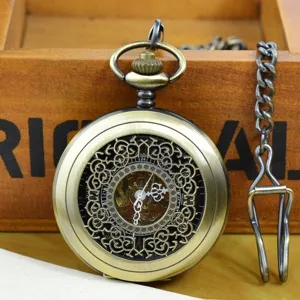 Close-up shot of vintage mechanical pocket watch with hollow floral dial and chain.