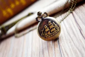 Vintage bronze pocket watch with exquisite sailing ship relief design and long matching chain.