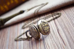 Detailed shot of the vintage bronze pocket watch with exquisite ship relief and chain.