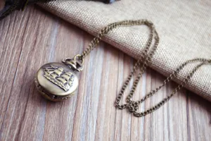 Vintage bronze pocket watch with sailing ship relief, classic retro quartz timepiece with long chain.