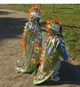 Detailaufnahme des Kinder Dinosaurier Umhangs mit glänzenden Schuppen und orangeen Stacheln.