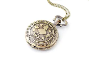 Détail de montre de poche en bronze vintage, motif gravé Alice au pays des merveilles.