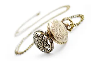 Detail view of vintage bronze hollow floral pocket watch with matching chain accessory.