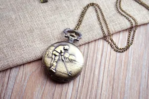 Dettaglio primo piano orologio da tasca golf bronzo vintage, modello retro con catena lunga.