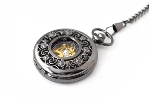 Detailed view of vintage black mechanical pocket watch with hollow floral carved design and chain.