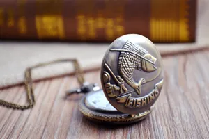 Vintage bronzen zakhorloge met vispatroon reliëfdeksel en een mooie bijpassende ketting.