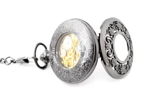 Vintage hollow mechanical pocket watch with intricate engraved case and metallic chain.