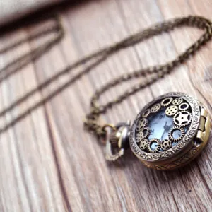 Vintage bronze pocket watch with hollow gear cover and long sweater chain necklace.