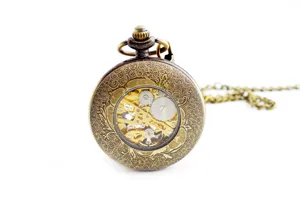 Vintage mechanical pocket watch with intricate carved case and hollow gear dial for men and women.