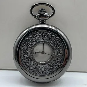 Vintage hollow quartz pocket watch detail view showcasing intricate metallic carved scrollwork.