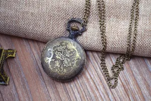 Vintage bronze pocket watch detail, hollow carved quartz timepiece with long chain.