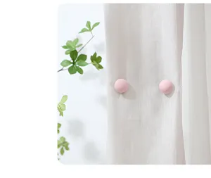 Quilt fastener detail showing secure pink button clip on white fabric with leaf accent.