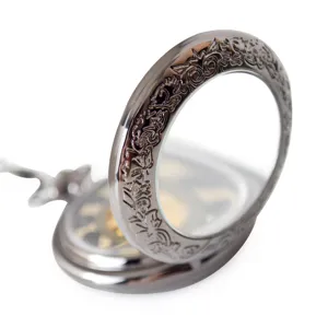 Detailed shot of vintage mechanical pocket watch with carved flip cover and transparent glass.