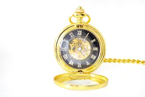 Detail view of a vintage gold mechanical pocket watch showing Roman numerals and skeleton dial.