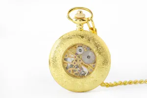 Vintage gold mechanical pocket watch with transparent skeleton dial and chain detail.